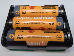 3 AA batteries installed in the back of an AudioMoth device.