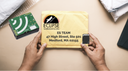 Hands placing a MicrSD card into a padded envelope with Eclipse Soundscapes logo and address.