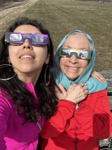 A mother and daughter wearing eclipse glasses.