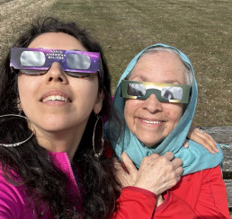 A mother and daughter wearing eclipse glasses.