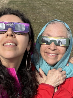 A mother and daughter wearing eclipse glasses.