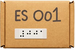 Small square cardboard box with the number 001 written in large print and a braille label attched in the bottom left corner.